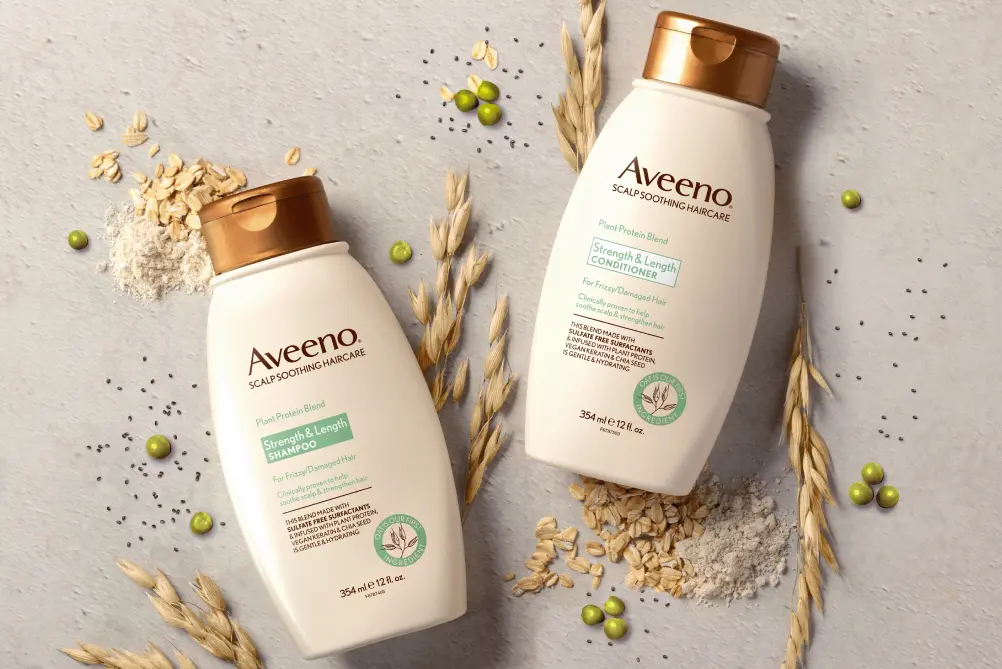 Aveeno® Strength & Length haircare set displayed with its nourishing ingredients for frizz control