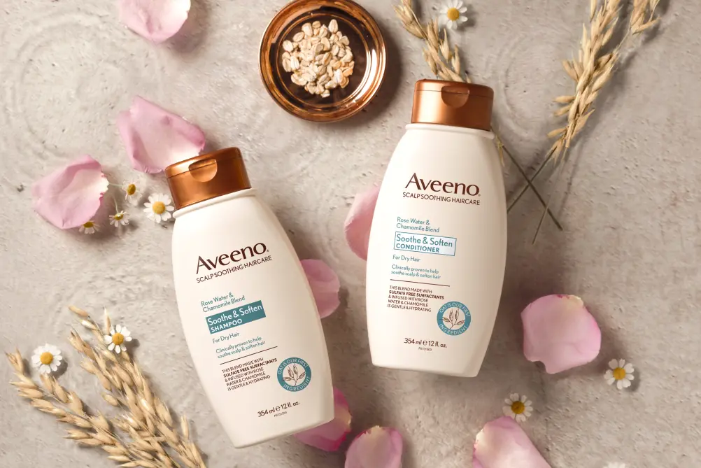Aveeno® Soothe & Soften Shampoo and Conditioner set displayed with its nourishing ingredients to soften hair