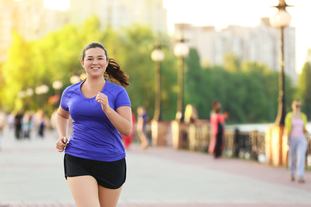 A woman smiles as she jogs.
